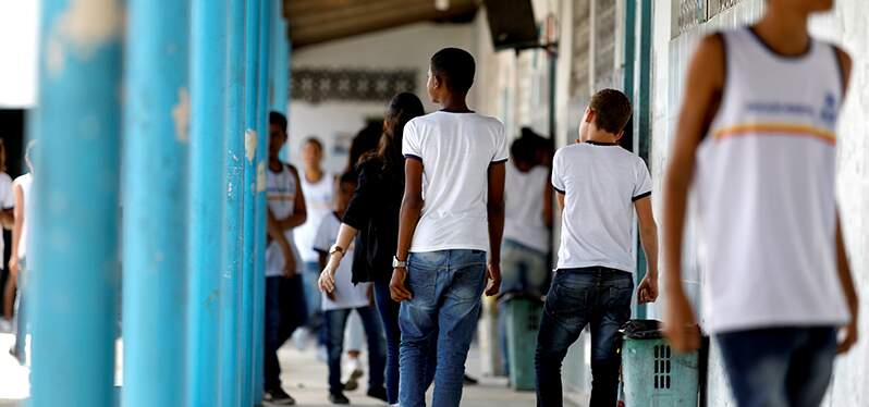 Crianças andando em corredor escolar. Foto: Adobe Stock