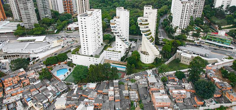 Prédio de luxo divide espaço com região periférica em São Paulo. Foto: Adobe Stock